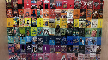 A variety of book covers put together to make the colour of the rainbow